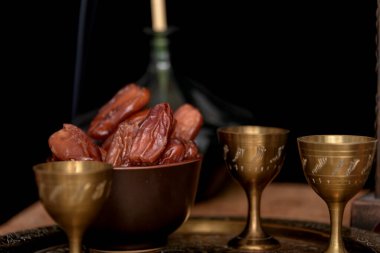 Ramazan konsepti. Tarihler ön planda yakın plan. Ahşap bir masada Ramazan Feneri. Desenli siyah duvar arkaplanı.