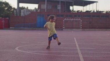 Küçük oğlan parkta top oynuyor. Mutlu aile çocuğu hayali konsepti. Bebek doğa parkında futbol oynuyor. Bebek parkta eğlence olsun diye topa vuruyor. Mutlu aile çocukluğu
