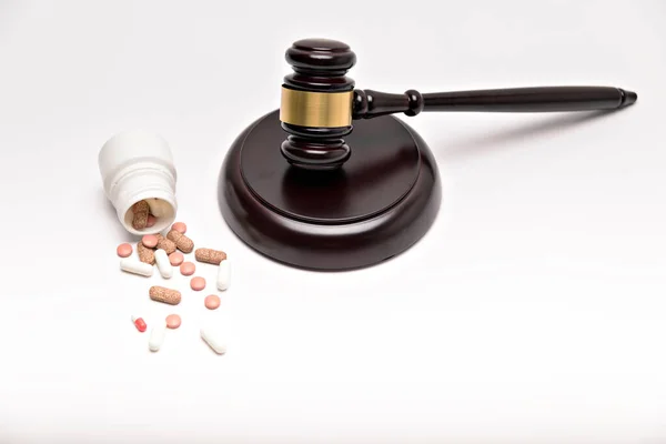 Medicine law concept. Gavel, stethoscope and pills isolated on white