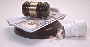 Pills and can of pills falling on a judges gavel on a white background. Concept For Medical Negligence, Bail, Monetary Compensation, Drugs Falsification