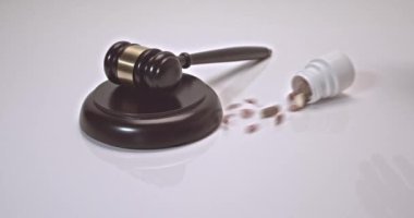 Pills and can of pills falling on a judges gavel on a white background. Concept For Medical Negligence, Bail, Monetary Compensation, Drugs Falsification