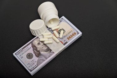 Siyah arka planda dolar ve beyaz haplar.