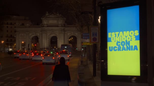 Μια Γυναίκα Περπατά Δίπλα Μια Φωτεινή Πινακίδα Μπλε Και Κίτρινα — Αρχείο Βίντεο