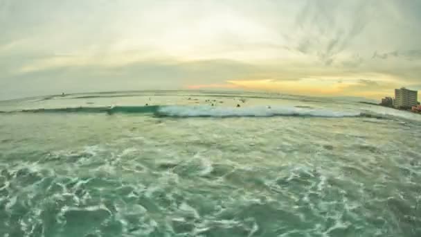 Golven en surfers tijdens zonsondergang — Stockvideo