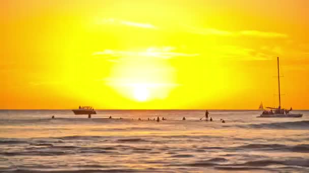 Surfers και βάρκες πηγαίνοντας από κατά τη διάρκεια του ηλιοβασιλέματος — Αρχείο Βίντεο