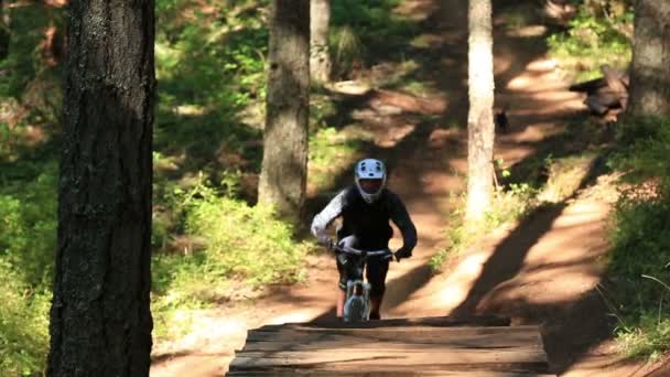 Ciclista de montaña va sobre saltos — Vídeo de stock