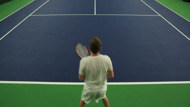 Jeune homme pratiquant ses compétences de tennis — Video