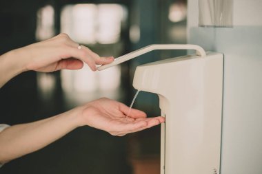 Doktor kadın elleri hastanede dezenfektan kullanıyor.