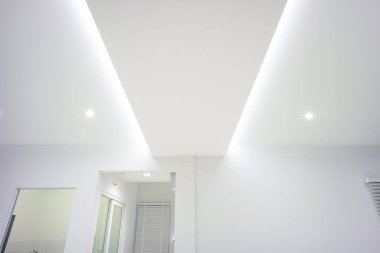 LED ışık ve aydınlatma. Ayrıca boş oturma odasındaki sıva tahtasının tavanına asılı duran kurdele ışığı veya LED bant olarak adlandırılan şey aşağı ışık ve beyaz duvardır. İç tasarım ve teknoloji.