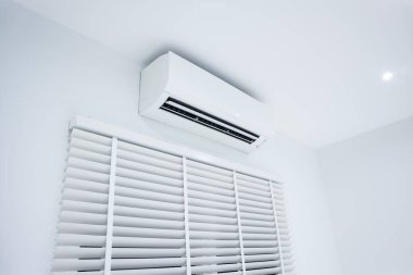 İklimi, sıcaklığı ve nemi kontrol etmek için havalandırma (ac) duvar montajı veya bölme sisteminin iç ünitesi. Doğal ışığı iç odaya ayarlamak için dikey ya da venedik jaluzileri de dahil et.