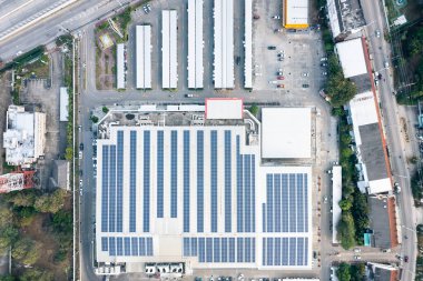 Hava görüntüsündeki yankı binası çatıdaki paneldeki güneş veya fotovoltaik hücreden oluşuyor. Elektrik enerjisi üretme teknolojisi, ışıkla elektrik akımı. Gelecek için yeşil temiz enerji.