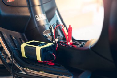 Elektrik, akümülatöre enerji, motorsiklet arızası ya da motorsiklette şarj oluyor. Ekipman aracını dahil et Taşınabilir şarj aleti, pozitif negatif klemp, kırmızı siyah kablo. May aradı, şarj et, kontrol et, onar.