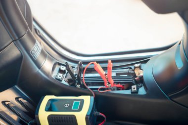 Elektrik, akümülatöre enerji, motorsiklet arızası ya da motorsiklette şarj oluyor. Ekipman aracını dahil et Taşınabilir şarj aleti, pozitif negatif klemp, kırmızı siyah kablo. May aradı, şarj et, kontrol et, onar.