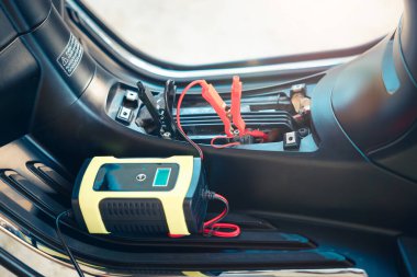 Elektrik, akümülatöre enerji, motorsiklet arızası ya da motorsiklette şarj oluyor. Ekipman aracını dahil et Taşınabilir şarj aleti, pozitif negatif klemp, kırmızı siyah kablo. May aradı, şarj et, kontrol et, onar.