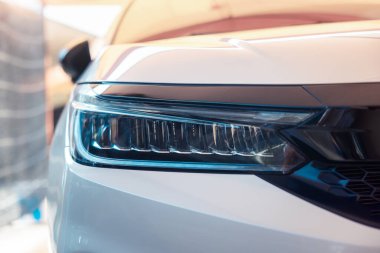 Araba farlarının yakın çekim detayları kurşun ampul, sinyal göstergesi, ışık, lamba parçası, gündüz çalışan ışıktan oluşur. Otomotiv, otomobil, lüks, cilalama, temizlik ve yıkama kavramı.