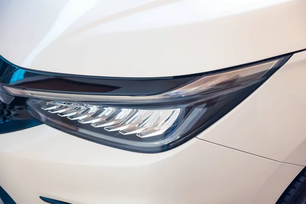 Closeup detail of headlight of auto car consist of led bulb, signal indicator turn light, lamp part, daytime running light. Concept for automotive vehicle, automobile, luxury, polish, clean and wash.