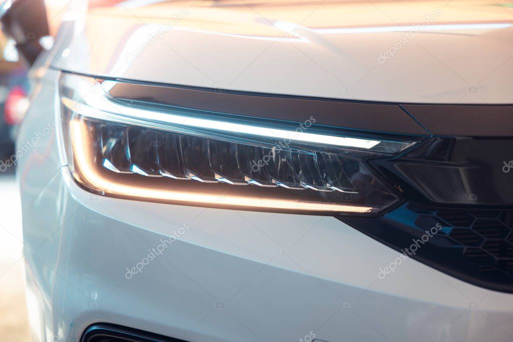 Closeup detail of headlight of auto car consist of led bulb, signal indicator turn light, lamp part, daytime running light. Concept for automotive vehicle, automobile, luxury, polish, clean and wash.