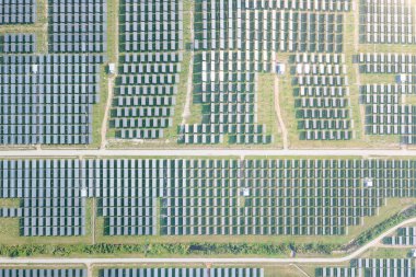 Hava görüntüsündeki güneş çiftliği, alan veya güneş enerjisi santrali panel, manzara ve teknoloji içindeki fotovoltaik hücreden oluşur. Elektrik endüstrisi, elektrik üretimi güneş ışığı veya güneş ışığı ile üretiliyor. Temiz ve yeşil güç, doğadan gelen sürdürülebilir enerji..