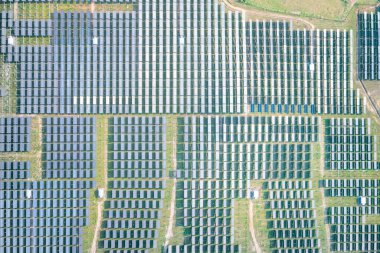 Hava görüntüsündeki güneş çiftliği, alan veya güneş enerjisi santrali panel, manzara ve teknoloji içindeki fotovoltaik hücreden oluşur. Elektrik endüstrisi, elektrik üretimi güneş ışığı veya güneş ışığı ile üretiliyor. Temiz ve yeşil güç, doğadan gelen sürdürülebilir enerji..