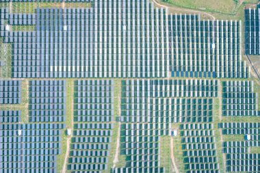 Hava görüntüsündeki güneş çiftliği, alan veya güneş enerjisi santrali panel, manzara ve teknoloji içindeki fotovoltaik hücreden oluşur. Elektrik endüstrisi, elektrik üretimi güneş ışığı veya güneş ışığı ile üretiliyor. Temiz ve yeşil güç, doğadan gelen sürdürülebilir enerji..
