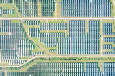 Hava görüntüsündeki güneş çiftliği, alan veya güneş enerjisi santrali panel, manzara ve teknoloji içindeki fotovoltaik hücreden oluşur. Elektrik endüstrisi, elektrik üretimi güneş ışığı veya güneş ışığı ile üretiliyor. Temiz ve yeşil güç, doğadan gelen sürdürülebilir enerji..