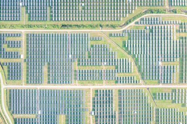 Hava görüntüsündeki güneş çiftliği, alan veya güneş enerjisi santrali panel, manzara ve teknoloji içindeki fotovoltaik hücreden oluşur. Elektrik endüstrisi, elektrik üretimi güneş ışığı veya güneş ışığı ile üretiliyor. Temiz ve yeşil güç, doğadan gelen sürdürülebilir enerji..