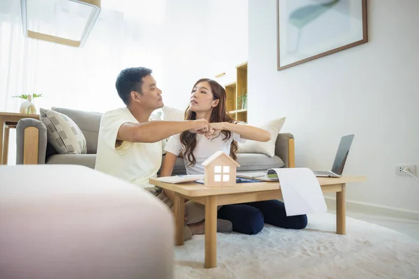 Asian couple in home or house. To bump punch, compare prices, interest, credit and calculate together. Include laptop, calculator and document on table. Concept for marriage, family, loan, finance.
