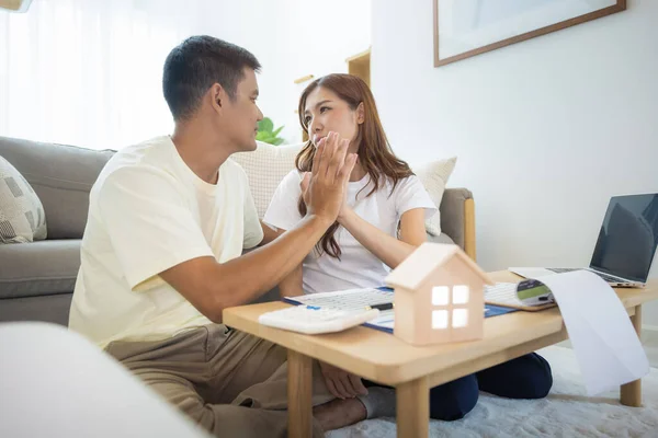 Asian couple in home or house. To compare prices, interest, credit. Include laptop, calculator and document on table. Concept for marriage, loan, finance, insurance, mortgage, real estate and property