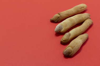 Cadılar Bayramı kurabiyeleri cadısının parmakları, kesilmiş kadın parmağı şeklinde, beyaz ve kırmızı arka plan. Uzayı kopyala parti yemeği