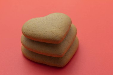 three heart shaped cookies on a red background. Valentines Day, greeting card, pastry, Copy space, top view, love concept, Engagement, copy space