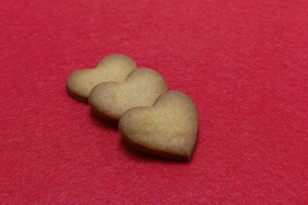 Trois biscuits en forme de coeur fond en feutre rouge. Saint Valentin, carte de souhaits, pâtisserie, Copier l'espace, vue de dessus, concept d'amour, Saint Valentin 14 février — Photo