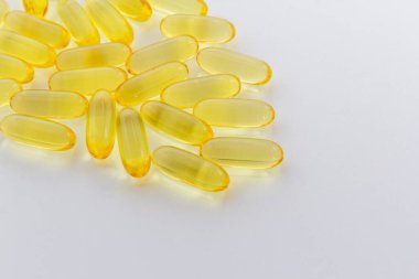 Beyaz arka planda balık yağı kapsülleri, sağlık geçmişi, dengeli diyet fotokopi alanı yatay görünüm