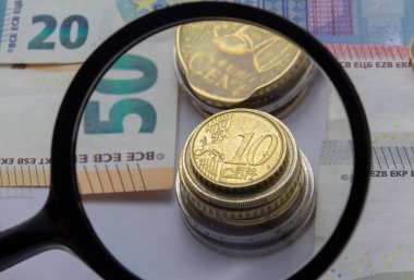 Para arka planında büyüteç, Avro paraları ve banknotlar. Para ve finansal kavramlar. Yatay, afiş, kapak, maket, tasarımınız için