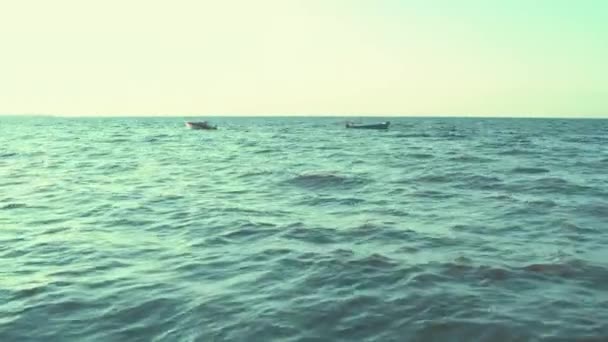 Zwei Boote treiben in verschiedenen Richtungen auf den Wellen im Meer. — Stockvideo