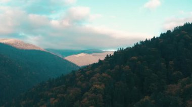 Dağlarda güzel bir gün batımı. Güneş ışınları bulutlar arasında parlıyor.