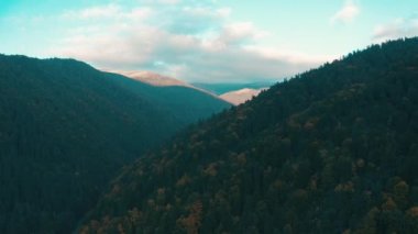 Dağlarda güzel bir gün batımı. Güneş ışınları bulutlar arasında parlıyor.