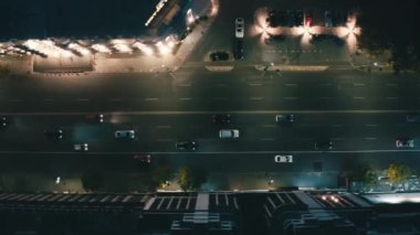 Arabalar gece şehrinin sokaklarında dolaşır. 4k görüntü. 