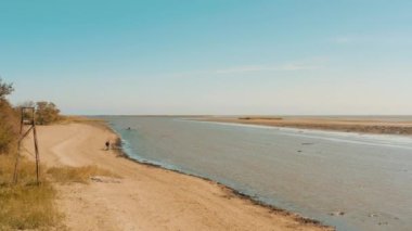Mariupol balıkçıları elle kıyıdan kabuklu deniz hayvanı topluyor. Barış zamanındaki şehir. 