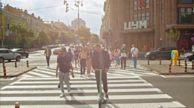 Kyiv, Ukrayna - Mayıs 2022: Birçok insan trafik ışıklarının yeşil ışıklarıyla karşıdan karşıya geçer. Kyiv şehrinin merkez caddesinde şehir içi trafik vardı. Yavaş Hareket 100fps 2.8k