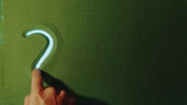 Yeşil Kum 'da 2022 numaralı el çizimi yılı sembolü. Erkek el yeşil kuma arka ışıklandırmalı bir numara yazıyor. Üst görünüm 4k çözünürlüğü