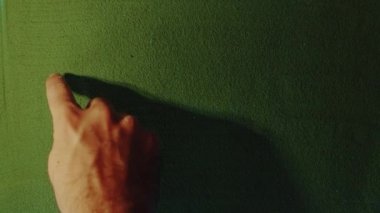 Yeşil Kum 'daki El Çizimi Yılı 2014 Sembolü. Erkek el yeşil kuma arka ışıklandırmalı bir numara yazıyor. Üst görünüm 4k çözünürlüğü