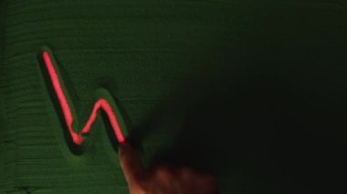 Yeşil Kum 'da Kelime Savaşı' nı elle çizmek. Erkek el, yeşil kuma kırmızı ışıkla 