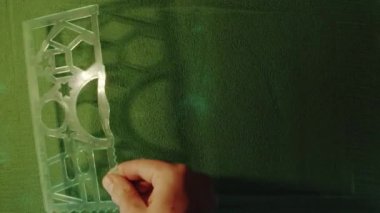 Yeşil Kum 'da Pasifik barış sembolünü elle çizmek ve sonra onu silmek. Erkek el yeşil kuma beyaz arka planda barış sembolü yazıyor. Üst görünüm 4k çözünürlüğü