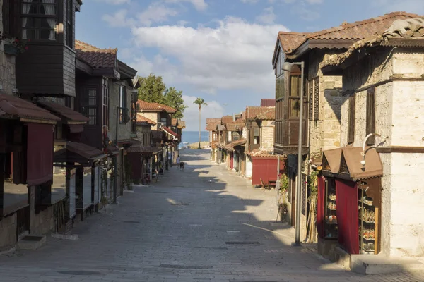Şehir merkezinin caddeleri, çarşı ve Antalya 'daki liman bölgesi. Sokak manzaralı. Gün batımı bulutlu gökyüzü. Kafe, restoran, dükkan ve evler. Kimse yok. Seçici Odaklanma