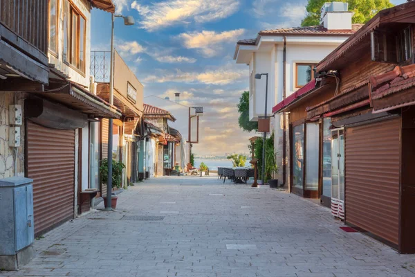 Şehir merkezinin caddeleri, çarşı ve Antalya 'daki liman bölgesi. Sokak manzaralı. Gün batımı bulutlu gökyüzü. Kafe, restoran, dükkan ve evler. Kimse yok. Seçici Odaklanma