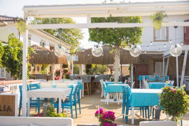 Mavi masaları ve sandalyeleri olan küçük bir deniz ürünleri restoranı. Antalya hindisi. Seçici Odaklanma tablosu.