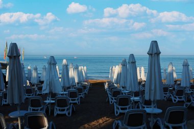 Deniz, sahil, şemsiyeler ve Antalya tarafındaki güneş pansiyonları. Bulutlu bir gökyüzü. Seçici Odaklanma. İnsan Yok.