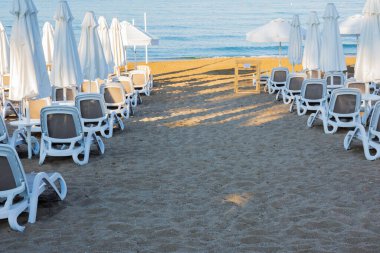 Deniz, sahil, şemsiyeler ve Antalya tarafındaki güneş pansiyonları. Bulutlu bir gökyüzü. Seçici Odaklanma. İnsan Yok.