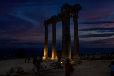 Apollo Tapınağı, M.S. 150 yılında Akdeniz kıyısında inşa edilmiş bir Roma tapınağıdır. Antalya hindisi. Gece ve bulutlu gökyüzü