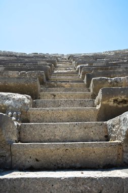 Güneşli bir günde mavi gökyüzü olan bir amfi tiyatroda merdivenler